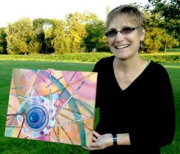 Julie Mader displays 'Wheel Around the Hub' which will be put up for auction at the Fire Hall after the race.